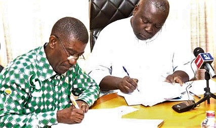 J. B. Koranteng-Yorke (right), Vice-President of the 1982 year group, and Henry Arthur-Gyan, the Headteacher of the school, signing copies of the contract